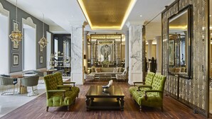 A luxurious lobby with green upholstered armchairs, a central coffee table, and a grand mirror with intricate designs. - TITANIC Gendarmenmarkt Berlin (Berlin)