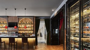 A bar area with a brick wall, shelves of bottles, and red pendant lights. - TITANIC Gendarmenmarkt Berlin (Berlin)
