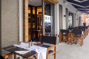 Un ristorante con posti a sedere all'aperto, interni in legno e vista sulla strada.