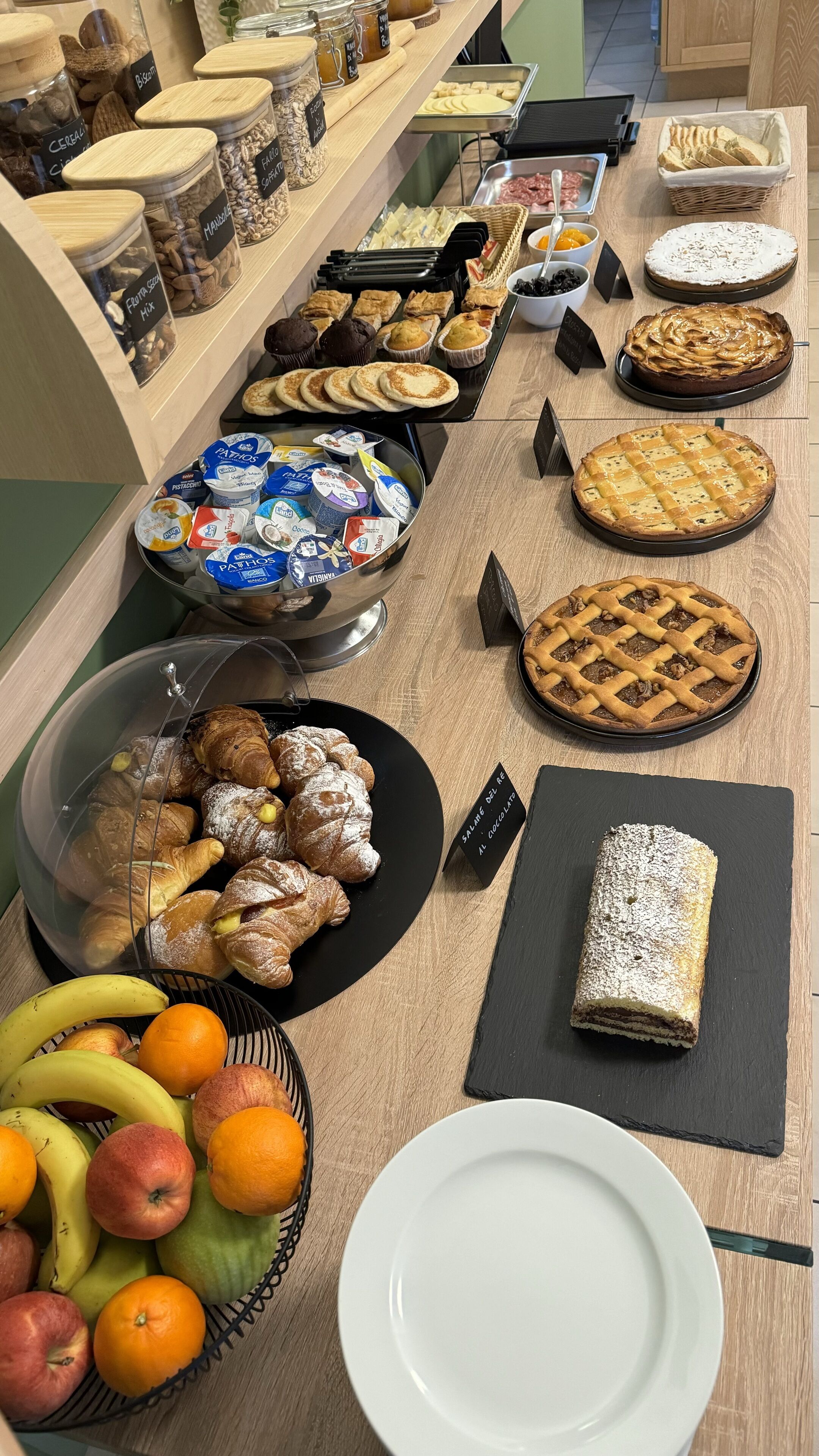 Ein Buffet mit verschiedenen Speisen, darunter Gebäck, Kuchen und Obst.