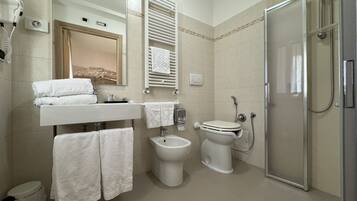 Ein modernes Badezimmer mit Toilette, Bidet, Waschbecken und Dusche.