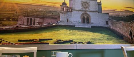 A dining area with a view of a historic church and surrounding landscape.
