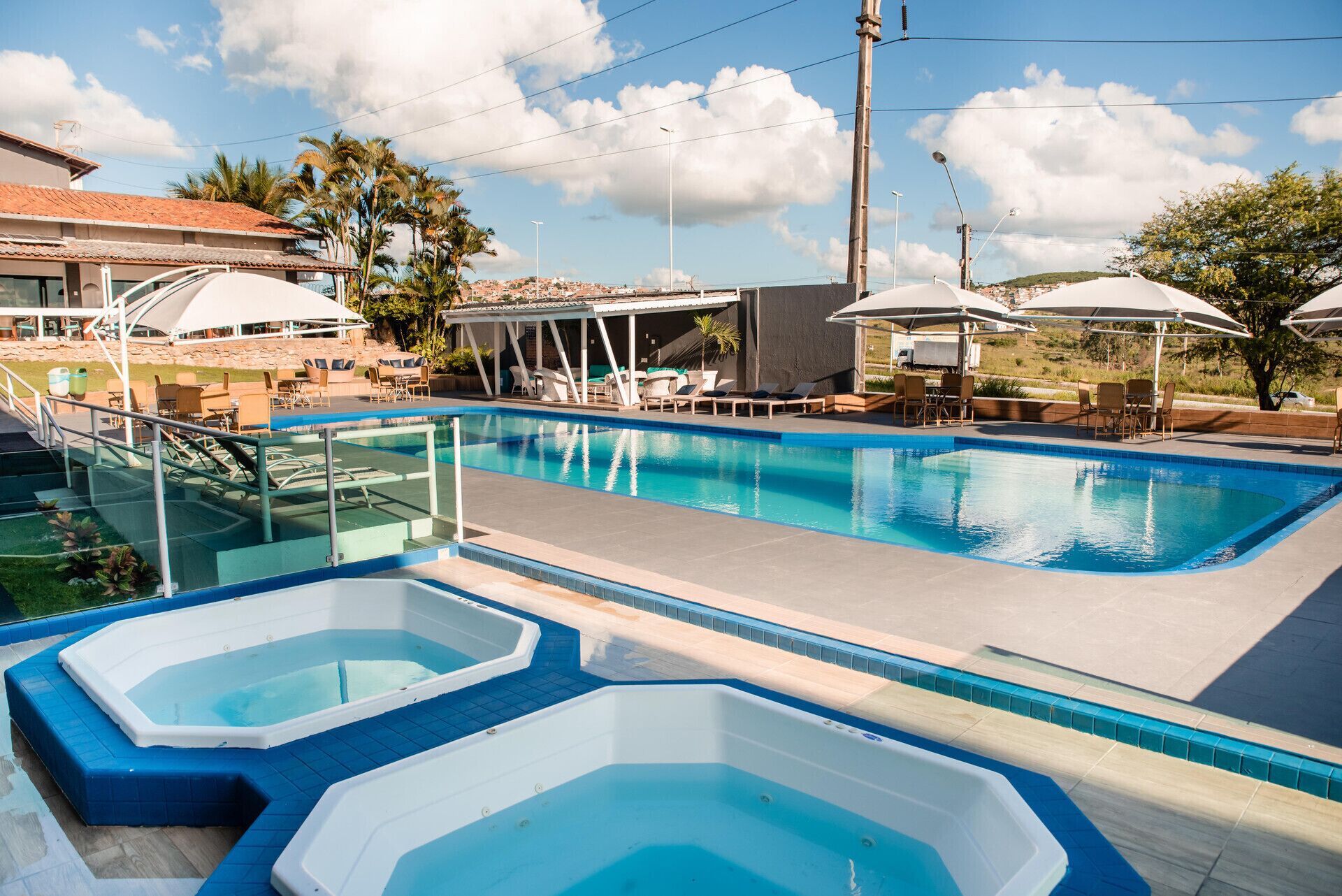 حمّام سباحة خارجي، مظلات على حمّام السباحة، مقاعد للتشمس