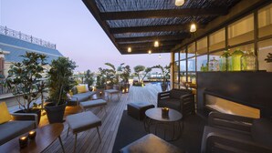 A rooftop terrace with outdoor seating, potted plants, and a view of the cityscape. - Serras Barcelona (Barcelona)