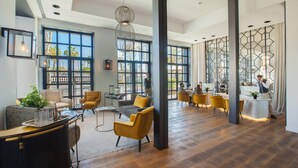 A spacious lobby with large windows, modern furniture, and a central seating area. - Serras Barcelona (Barcelona)