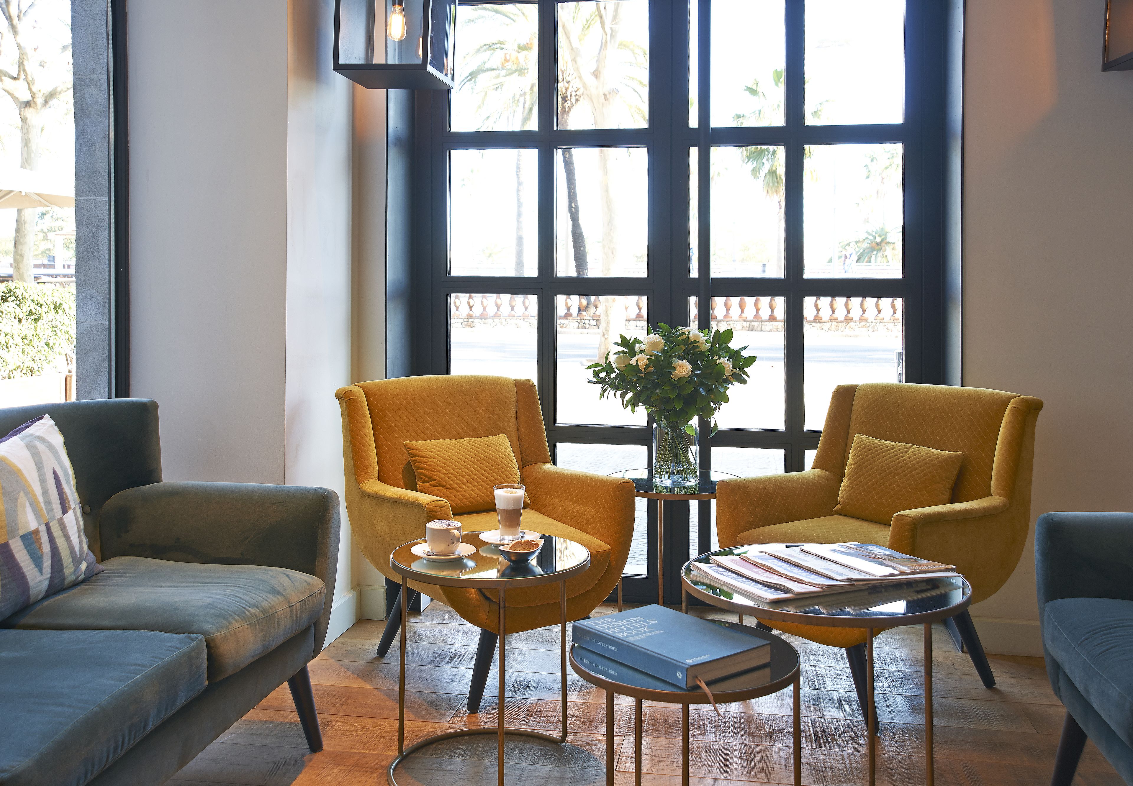 Una sala de estar moderna con un sofá, dos sillones, una mesita de centro y una estantería.