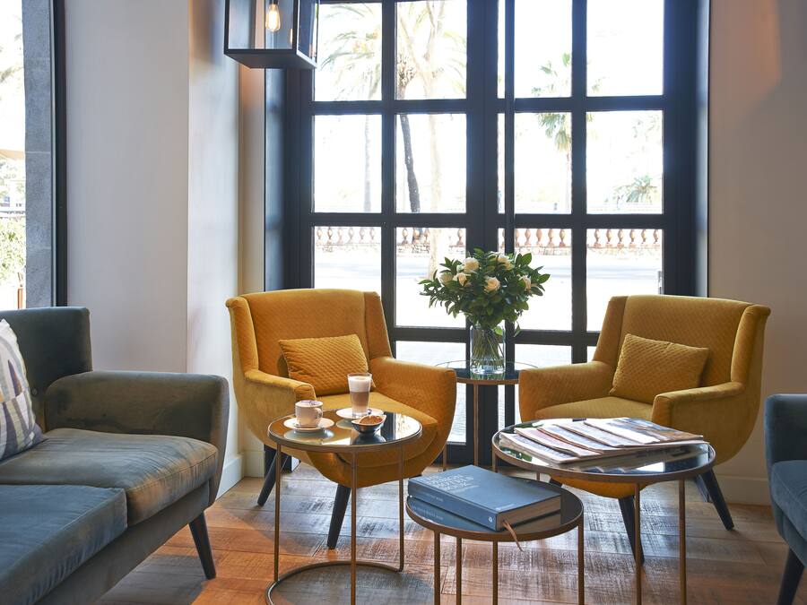 Una sala de estar moderna con un sofá, dos sillones, una mesita de centro y una estantería.