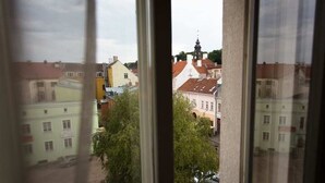 A view through a window of a cityscape with buildings and a church spire. - Hotel London Tartu (Tartu)