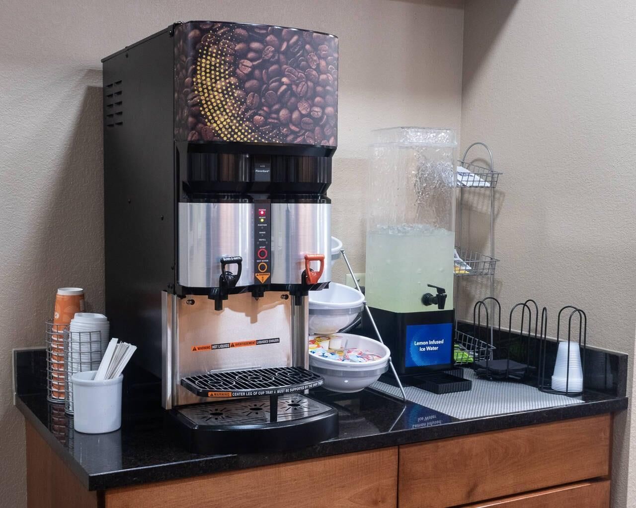 Un espace dédié au café, équipé d’une machine à café, d’un distributeur d’eau fraîche infusée au citron et d’un porte-gobelet.
