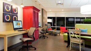 A modern office space with a desk, computer, chairs, and a couch. - Home2 Suites by Hilton Midland (Midland)