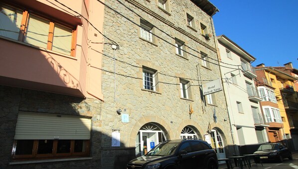 Un edificio de piedra con un cartel que indica que es un albergue.