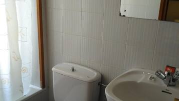 Une salle de bain avec des toilettes, un lavabo et un miroir.