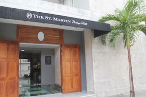 The entrance of The St. Martin Boutique Hotel with a wooden door and a glass display case. - KLR St Martin Boutique by Sercotel (Playa del Carmen)