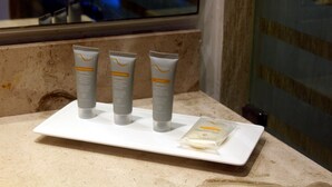 A bathroom counter with three skincare products and a soap bar. - Real Inn Cancun (Cancun)