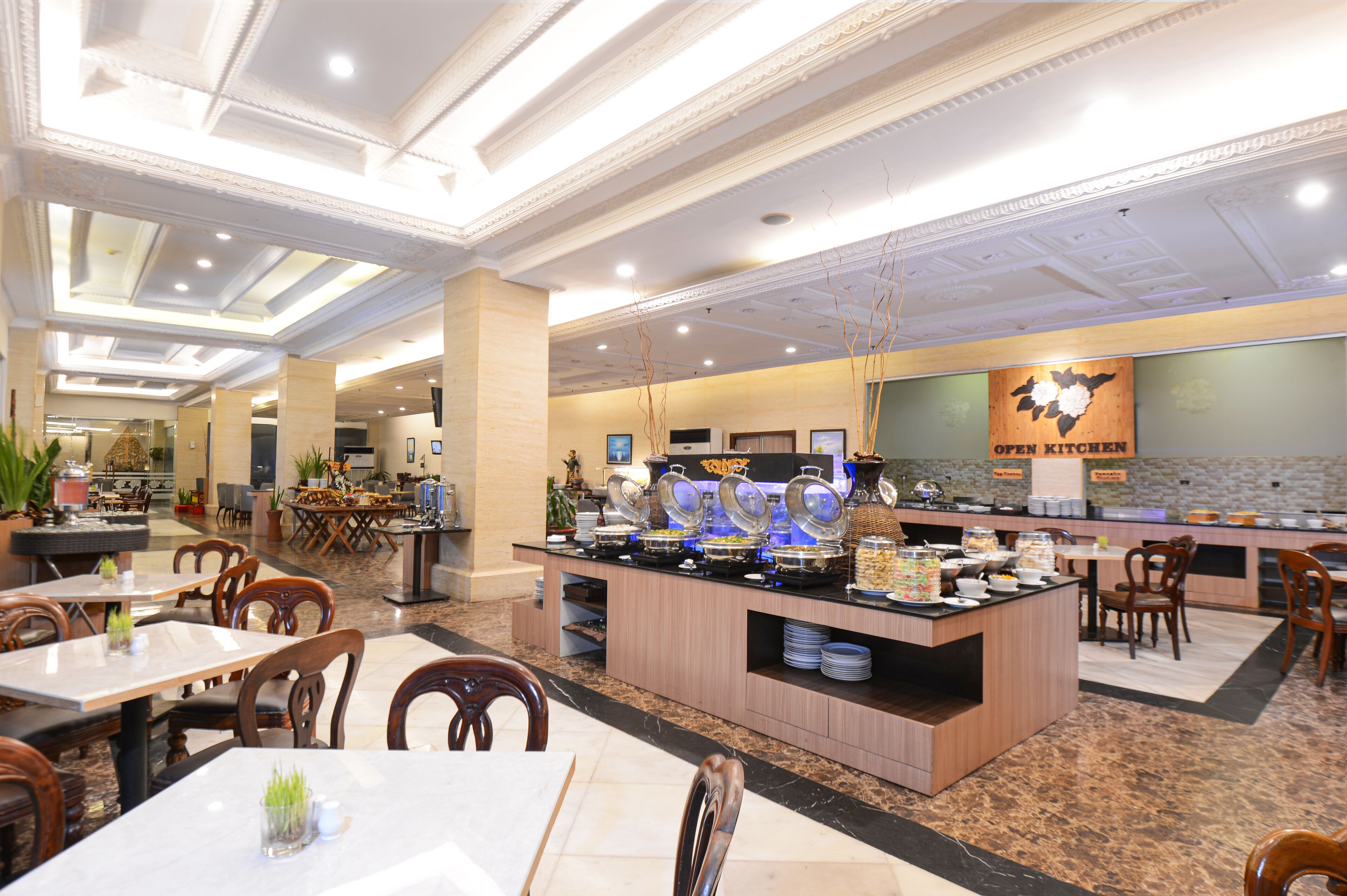 A buffet area with multiple serving stations, seating arrangements, and a 'OPEN KITCHEN' sign.