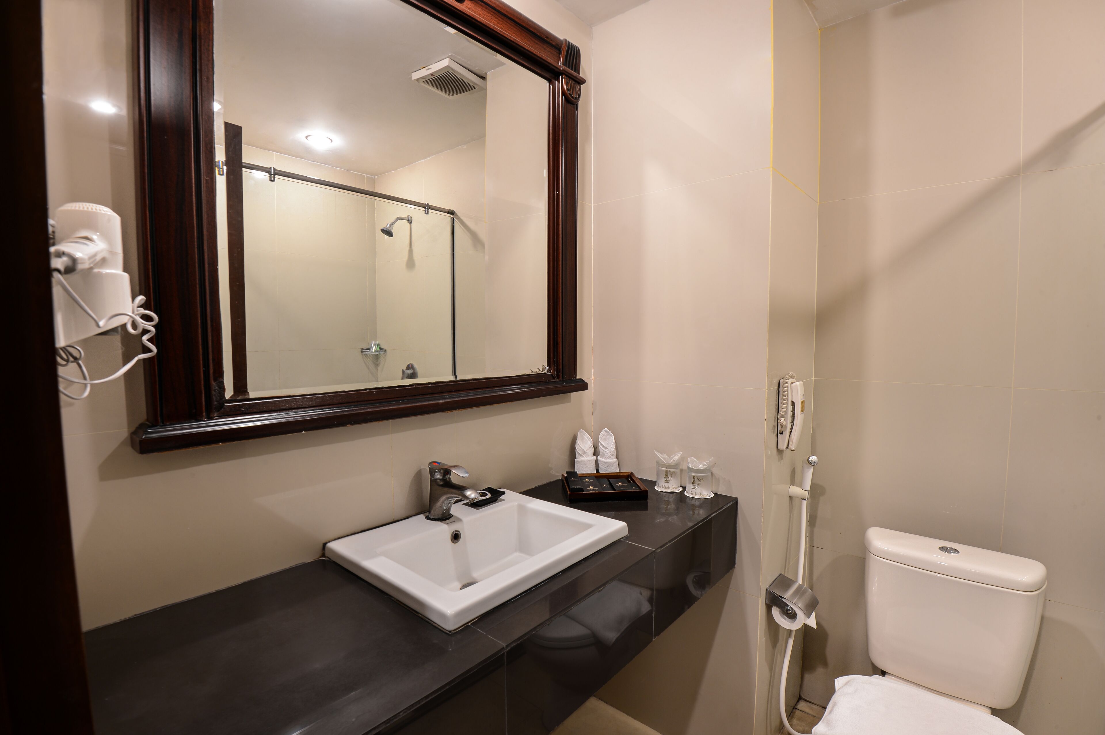 A modern bathroom with a white sink, a large mirror, and a shower.