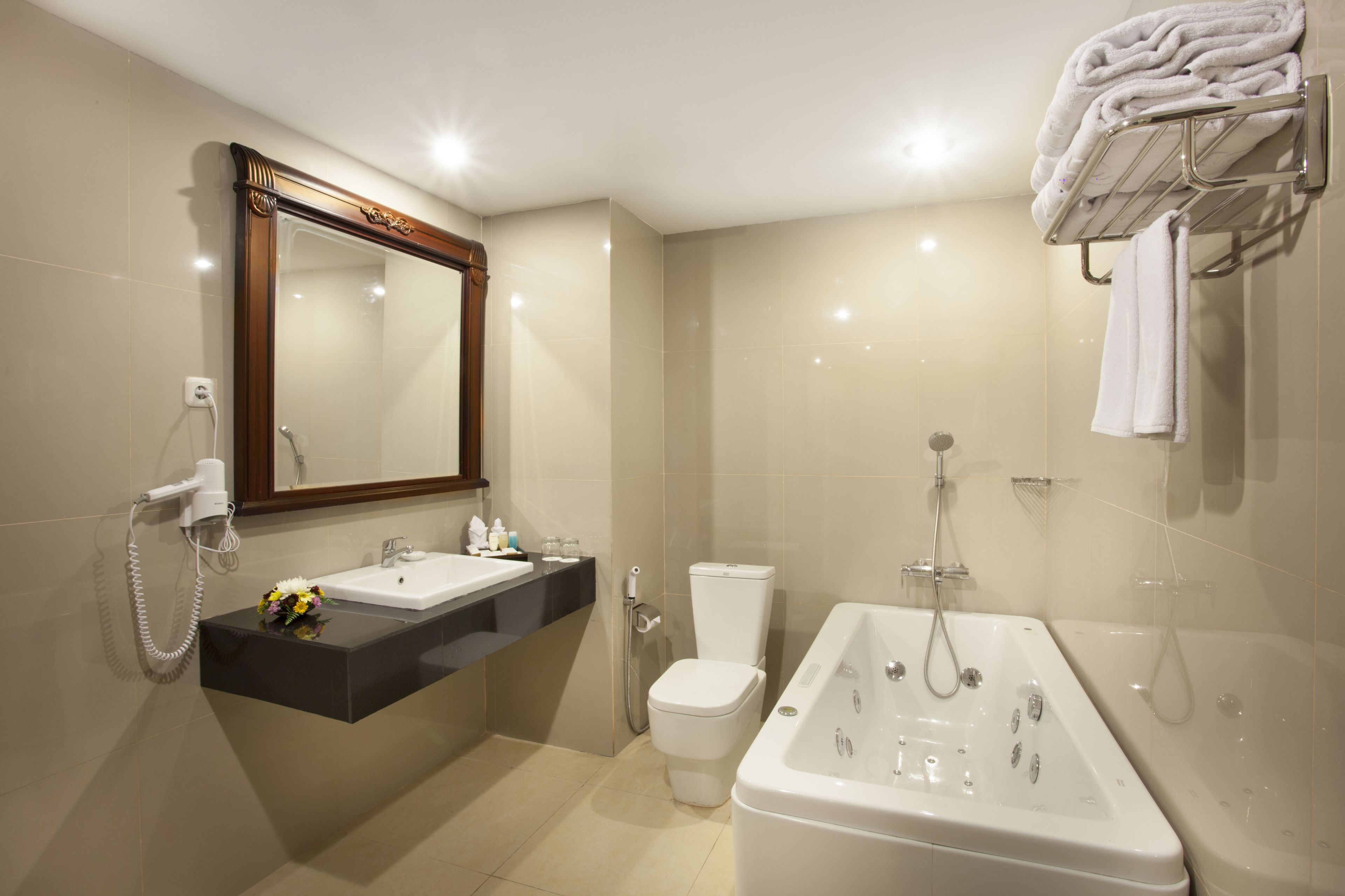 A modern bathroom with a vanity, toilet, bathtub, and towel rack.