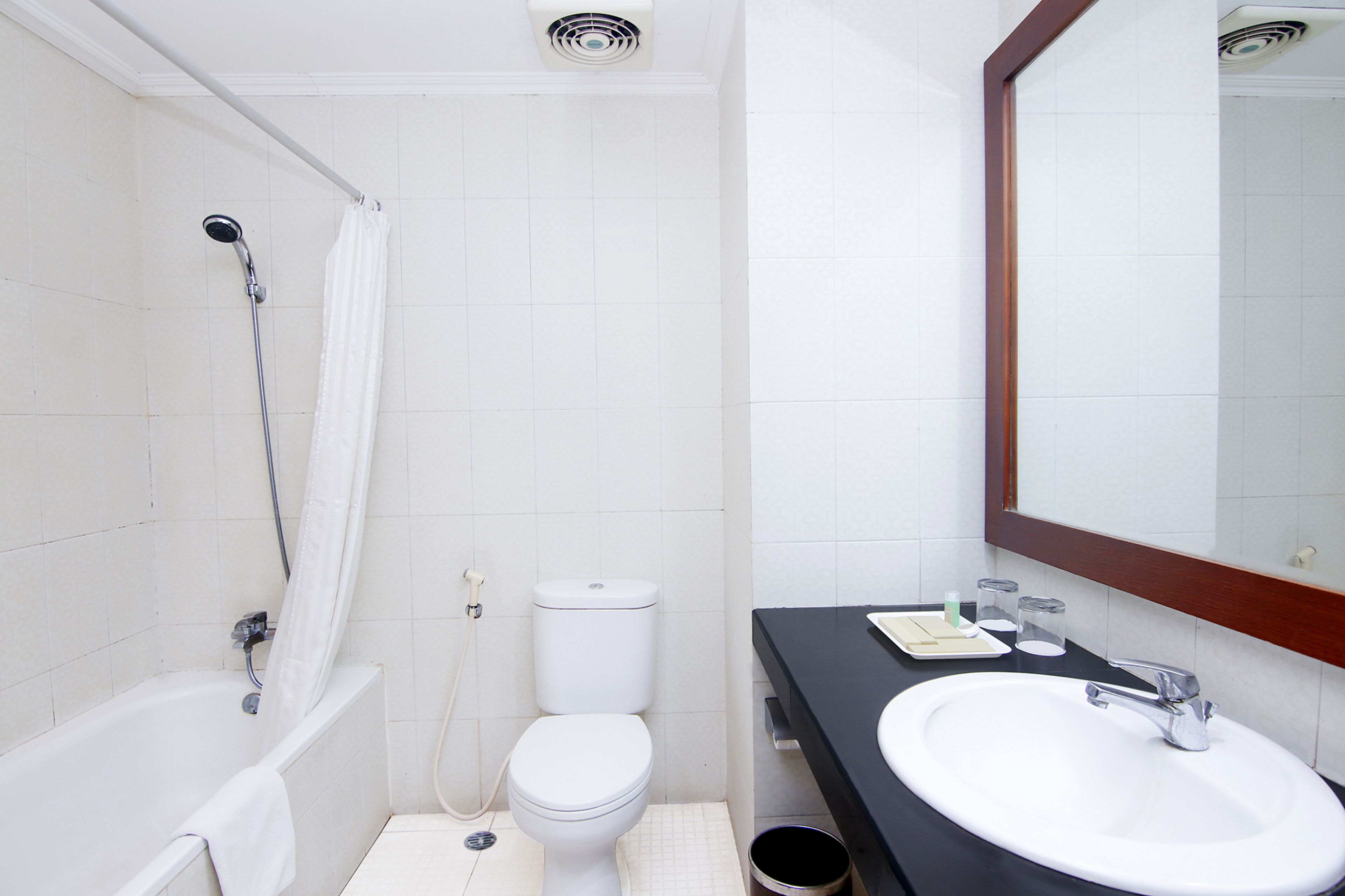 Ein Badezimmer mit Badewanne, Toilette, Waschbecken und Spiegel.