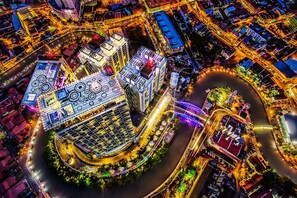 An aerial view of a modern urban area with illuminated buildings, a river, and a circular road. - Swiss-Garden Hotel Melaka (Malacca City)