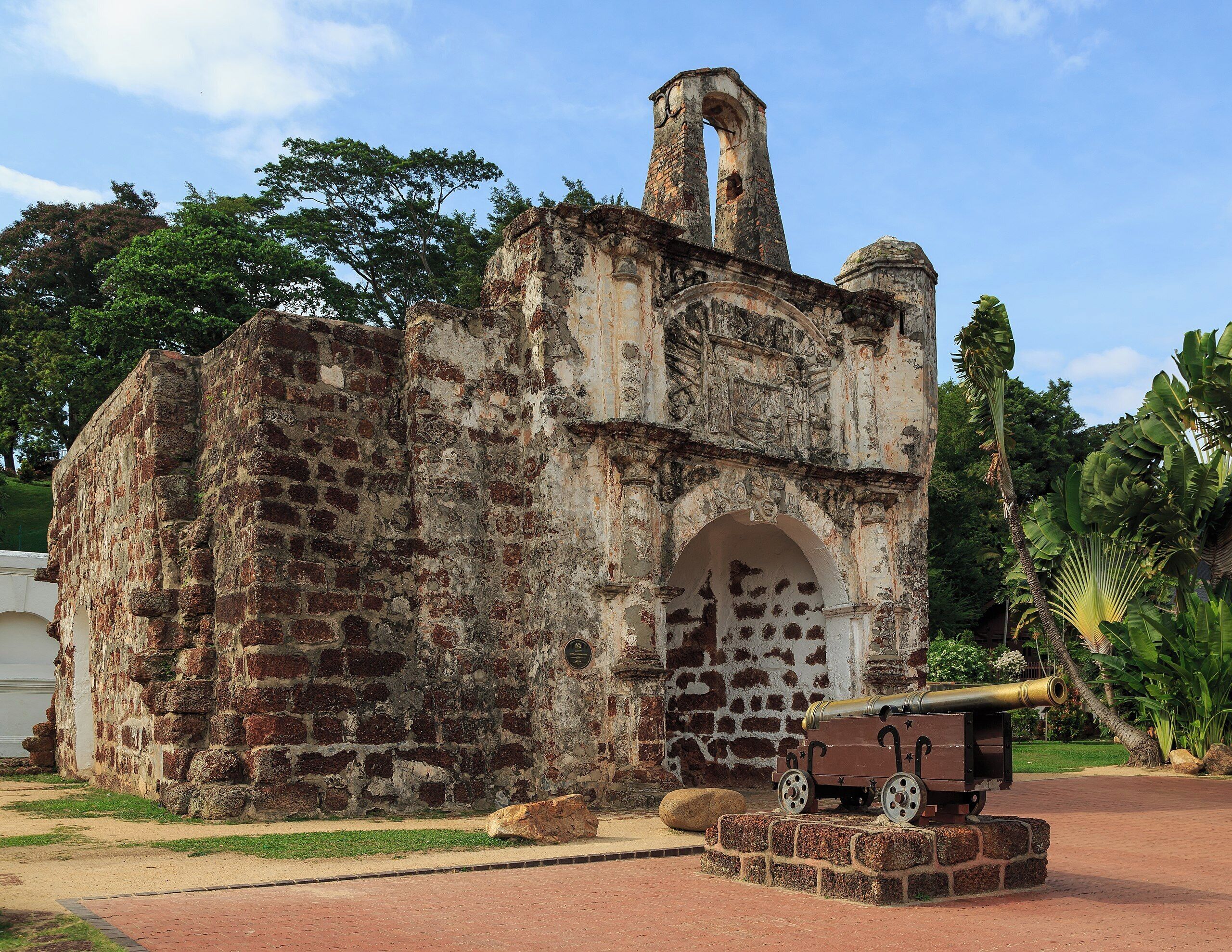 An old brick building with a large arched doorway and a bell tower.