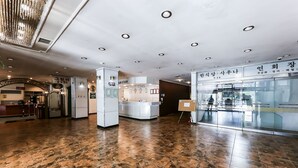 Un moderno vestíbulo de hotel con piso de baldosas pulidas, un mostrador de recepción y un escaparate de vidrio.
