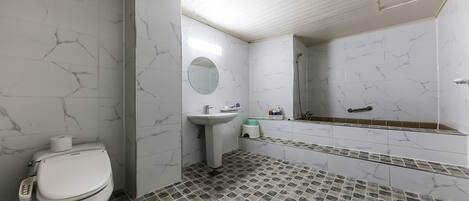 A bathroom with a toilet, sink, mirror, and shower.
