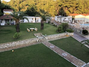 A well-maintained outdoor area with a stone pathway, seating area, and a pool. - Villa Christina (Skiathos)