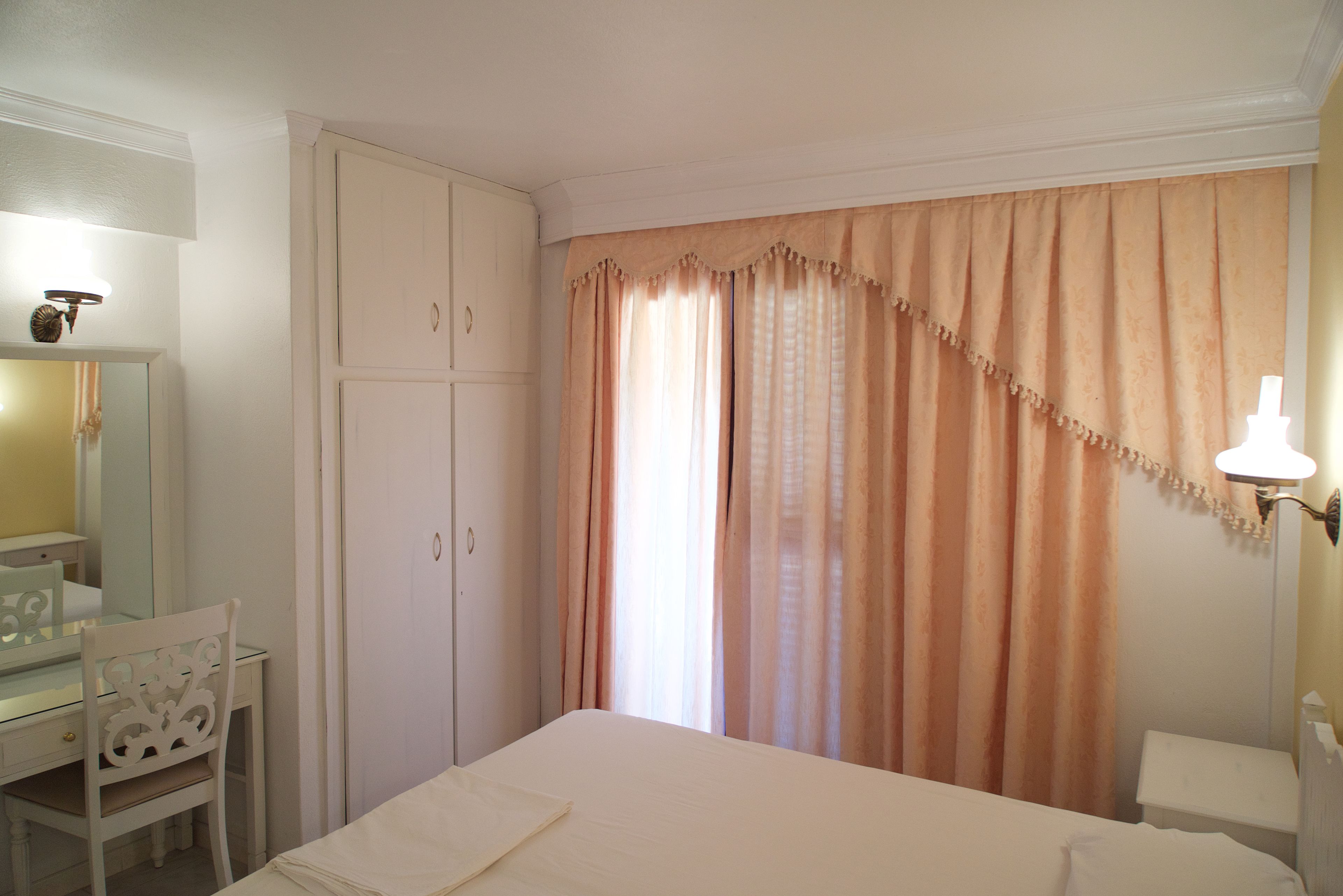 Un dormitorio con cama, escritorio y armario.
