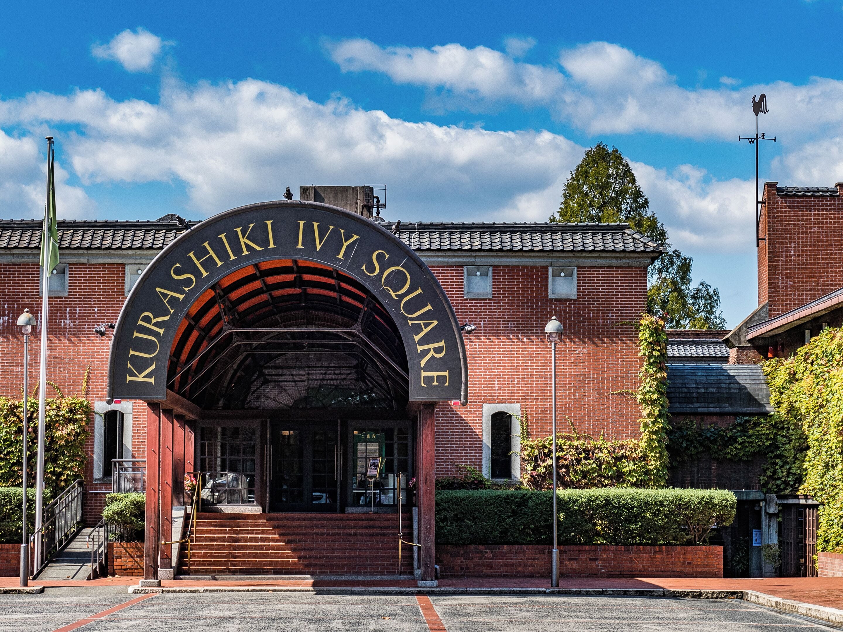 A brick building with a sign reading 'Kurashiki Ivy Square.'