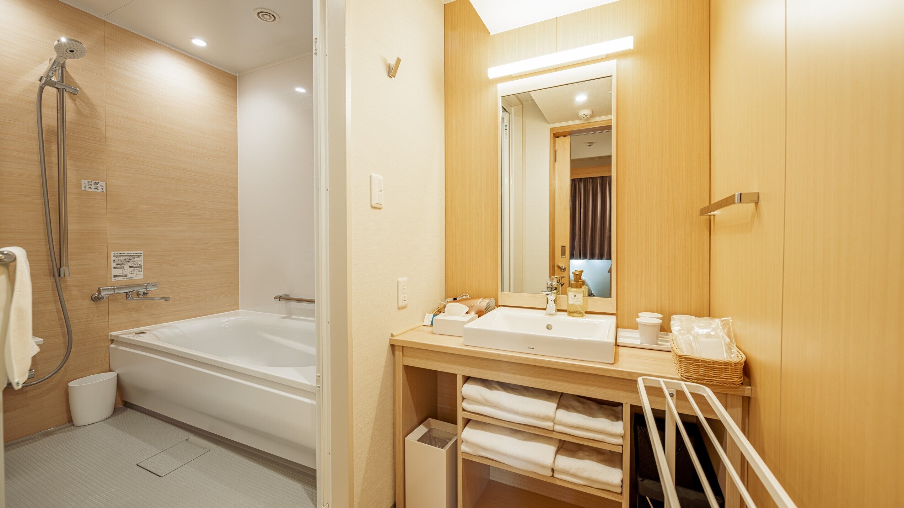 A modern bathroom with a bathtub, a shower, a sink, and a mirror.