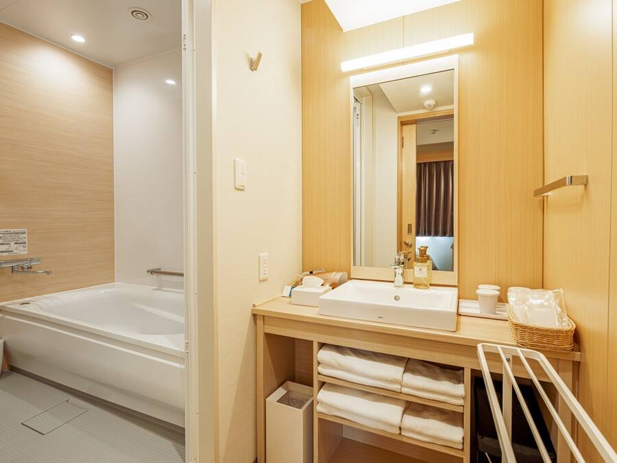 A modern bathroom with a bathtub, a shower, a sink, and a mirror.