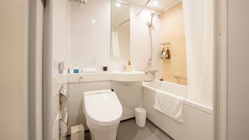 A modern bathroom with a toilet, sink, and bathtub.