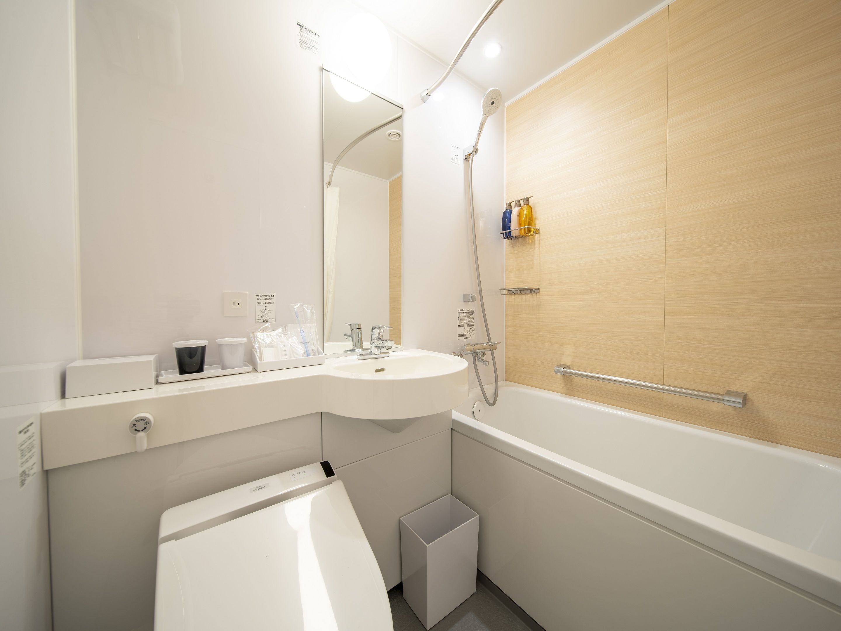 A modern bathroom with a white sink, mirror, and shower.