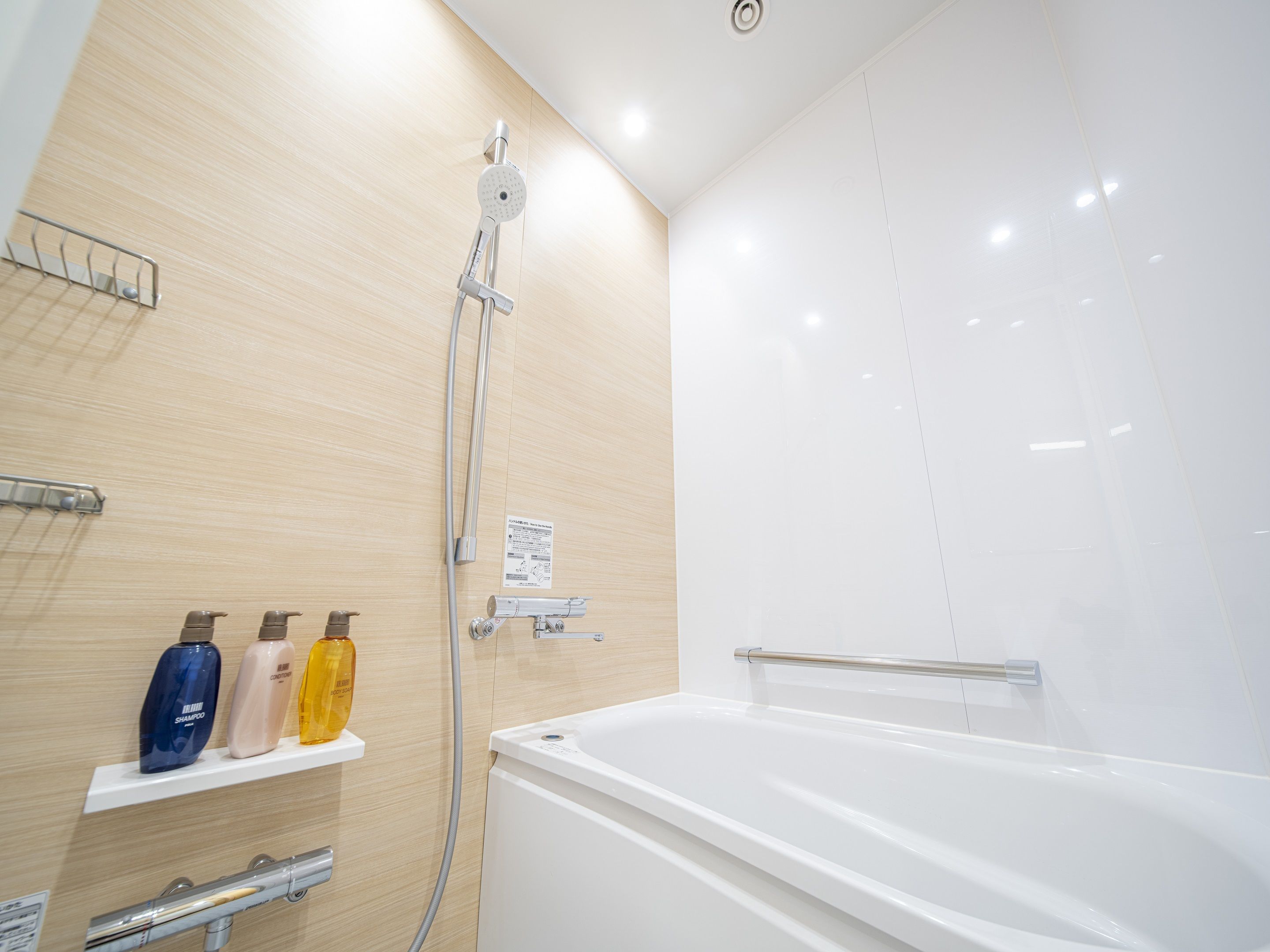 Un baño moderno con bañera, ducha y un estante con artículos de aseo.