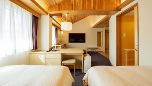 Una habitación de hotel con dos camas, un escritorio, una silla, un televisor y un armario.