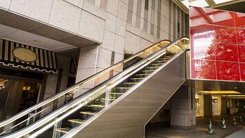An interior view of a modern building with an escalator leading to a lower level.