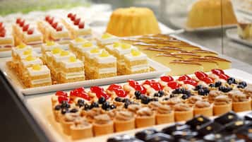 Eine Auswahl an Desserts, darunter Kuchen und Gebäck mit Früchten und Sahne.