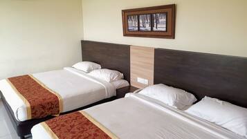 Due letti singoli con lenzuola bianche e bordi decorativi rossi, una testata in legno e un quadro appeso al muro.
