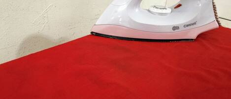 An iron on a red surface.