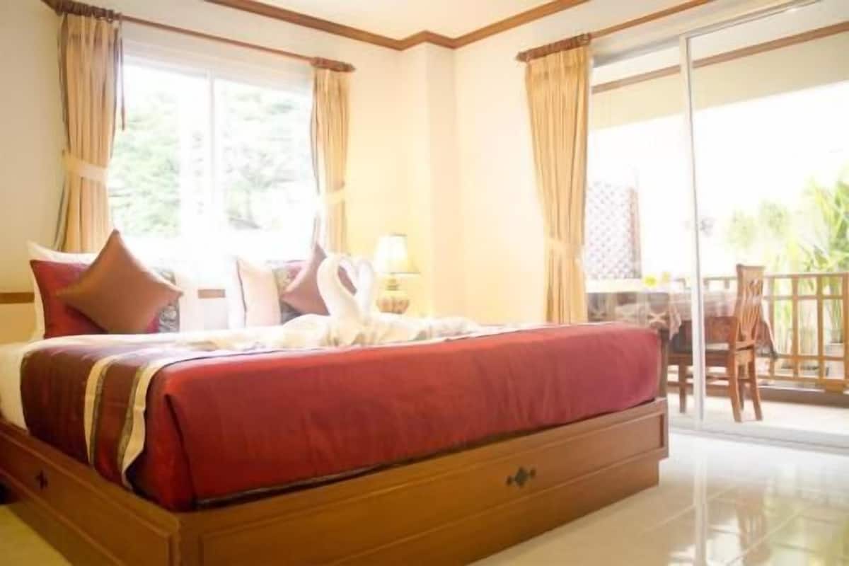 Quarto de hotel com uma cama, mesa, cadeiras e vista para o exterior.
