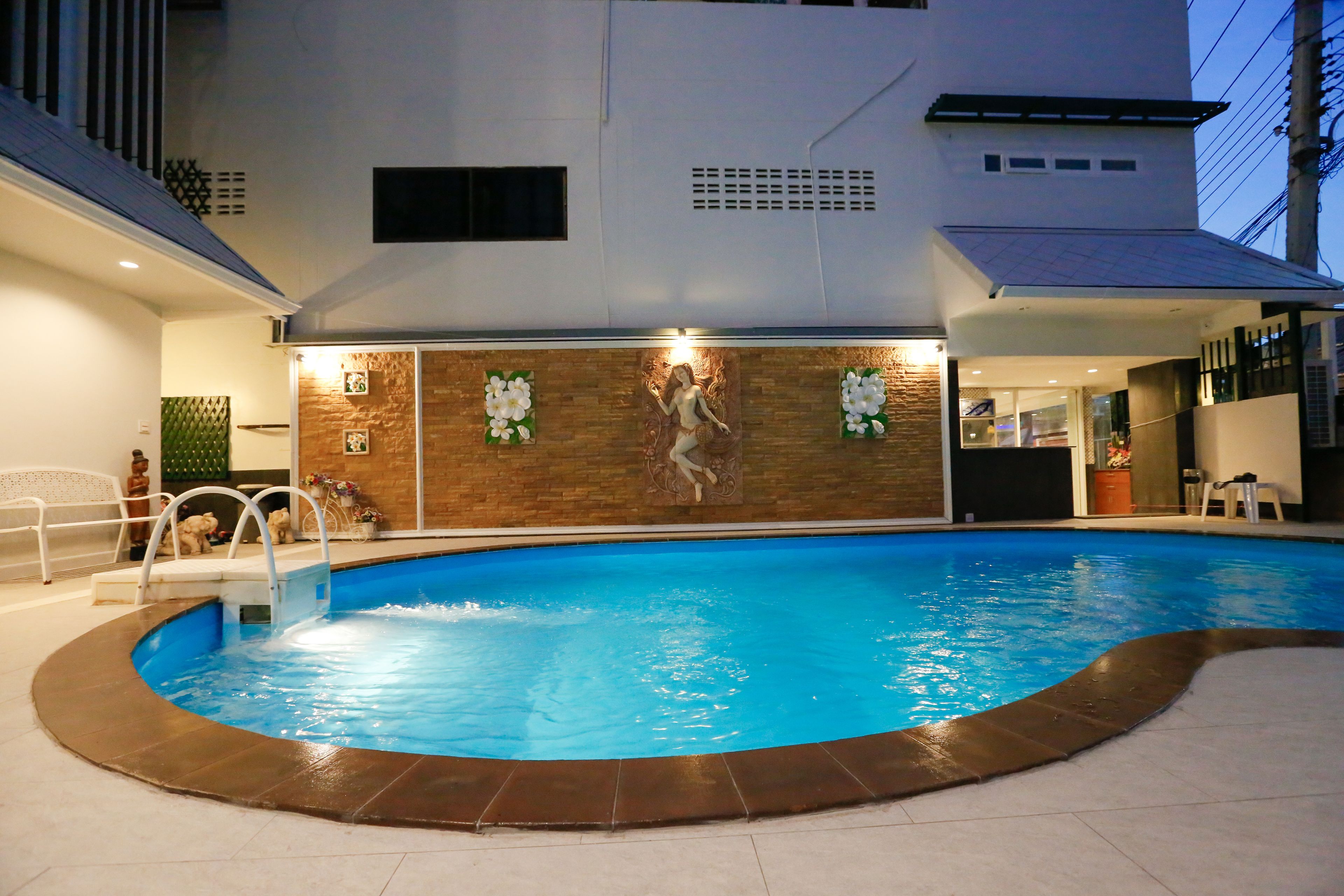An indoor swimming pool with a stone wall and decorative elements.