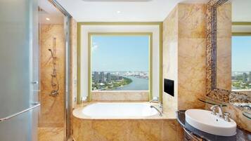 Ein modernes Badezimmer mit einer großzügigen Badewanne, einem separaten Waschbecken und einer Duschkabine aus Glas.