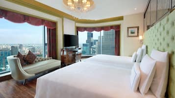 Una camera d'albergo con un letto grande, un divano, una televisione e vista sulla città.