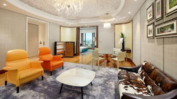 A modern living room with a chandelier, a sofa, armchairs, and a coffee table.
