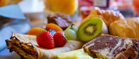 En frukostuppläggning med rostat bröd, frukt och ett glas apelsinjuice.
