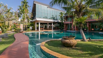 Una piscina al aire libre, sombrillas, sillones reclinables de piscina