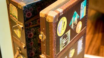 A vintage suitcase with multiple stickers and a floral design on the inside.