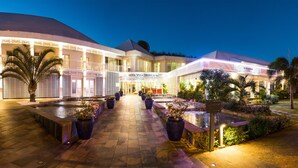 A hotel with a pool area, outdoor seating, and a well-lit entrance. - Villa Delisle Hôtel & Spa (Saint-Pierre)