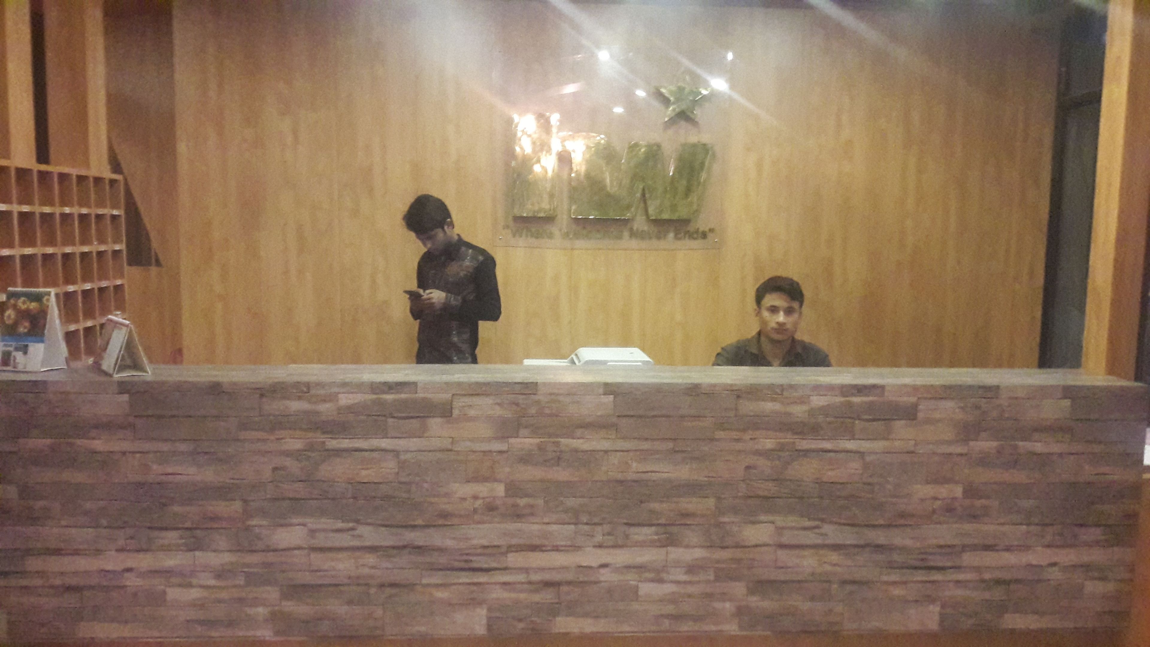 A reception desk with a wooden backdrop and a stone base.
