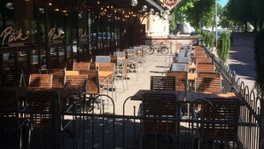Un café al aire libre con mesas y sillas, una valla y un edificio con un cartel que dice "Park restauranten".